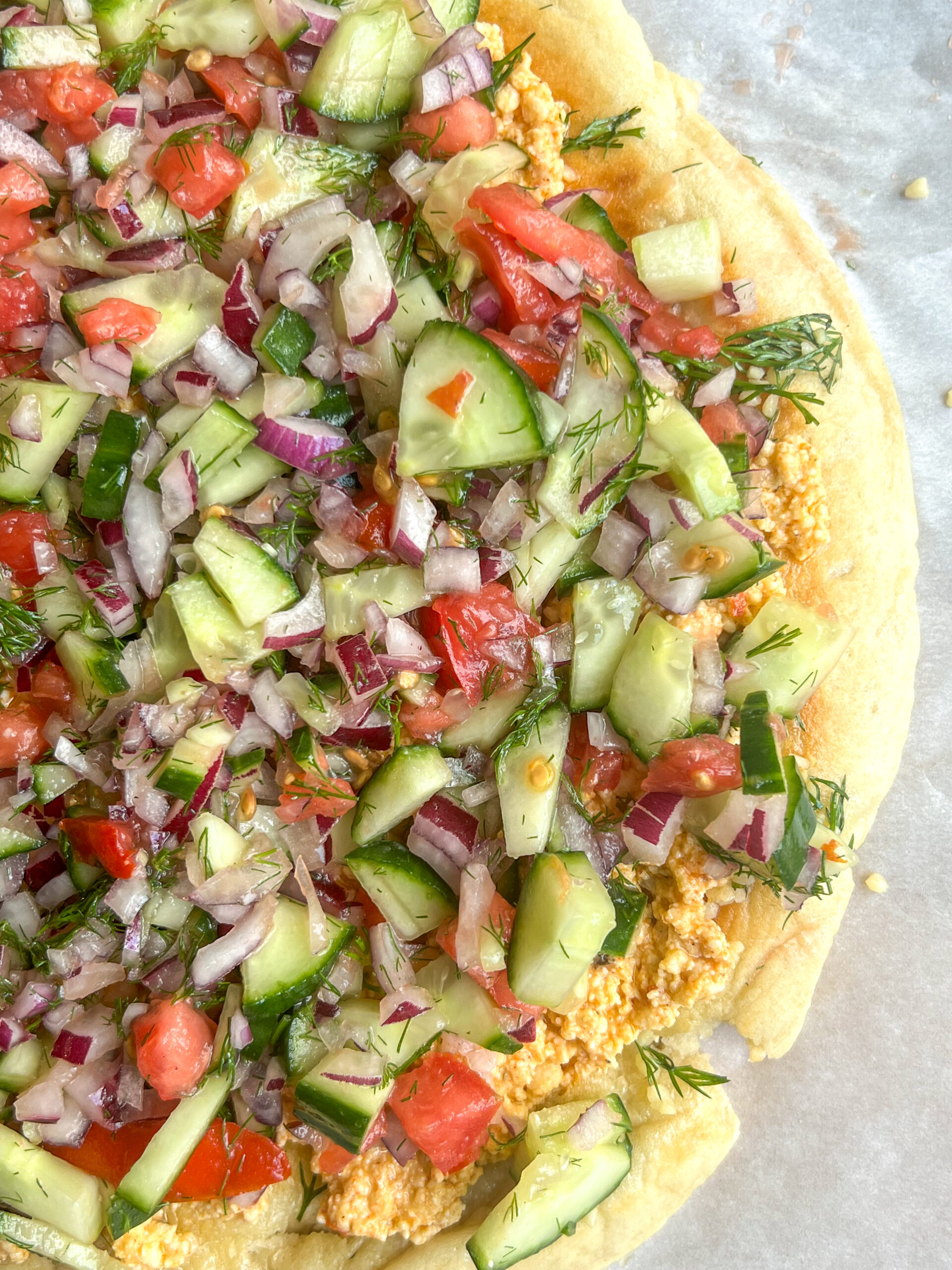 smashed feta flatbread topped with colorful veggies and herbs