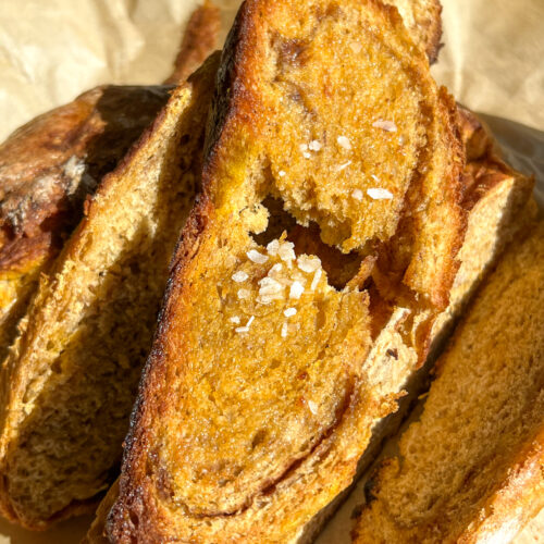 slices of pumpkin cinnamon swirl artisan loaf topped with flaky salt and butter