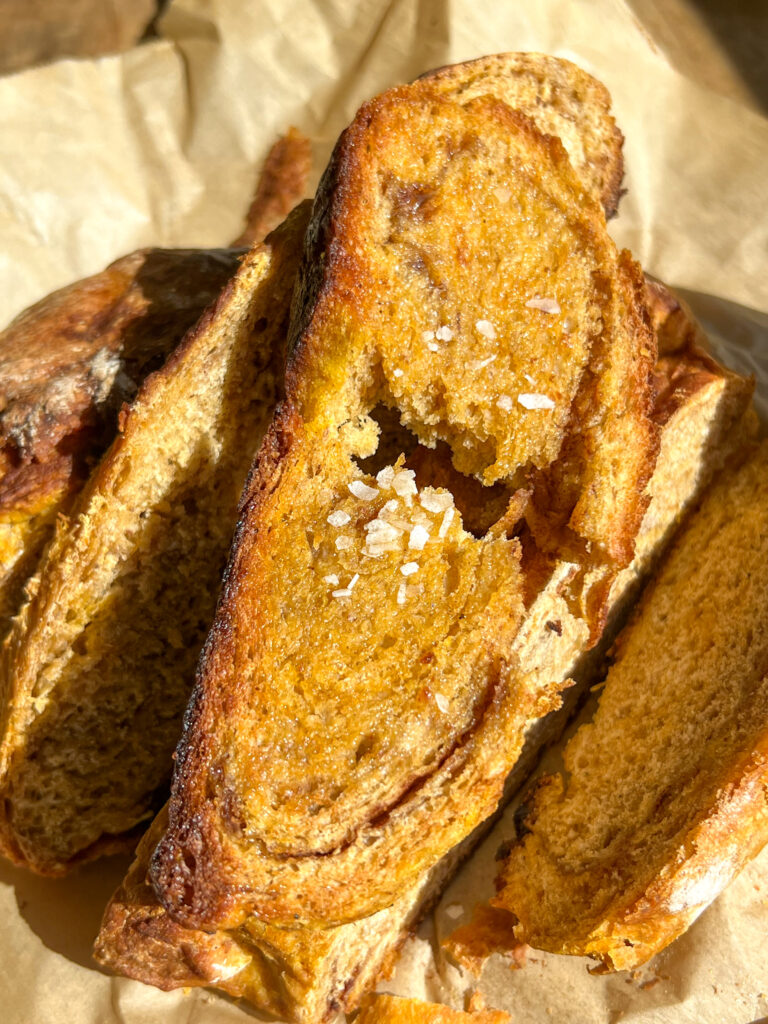 slices of pumpkin cinnamon swirl artisan loaf topped with flaky salt and butter