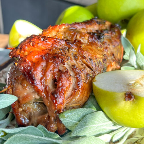 Glazed pear and herb pork roulade with pears in the background