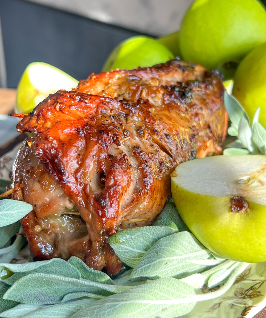 Glazed pear and herb pork roulade with pears in the background